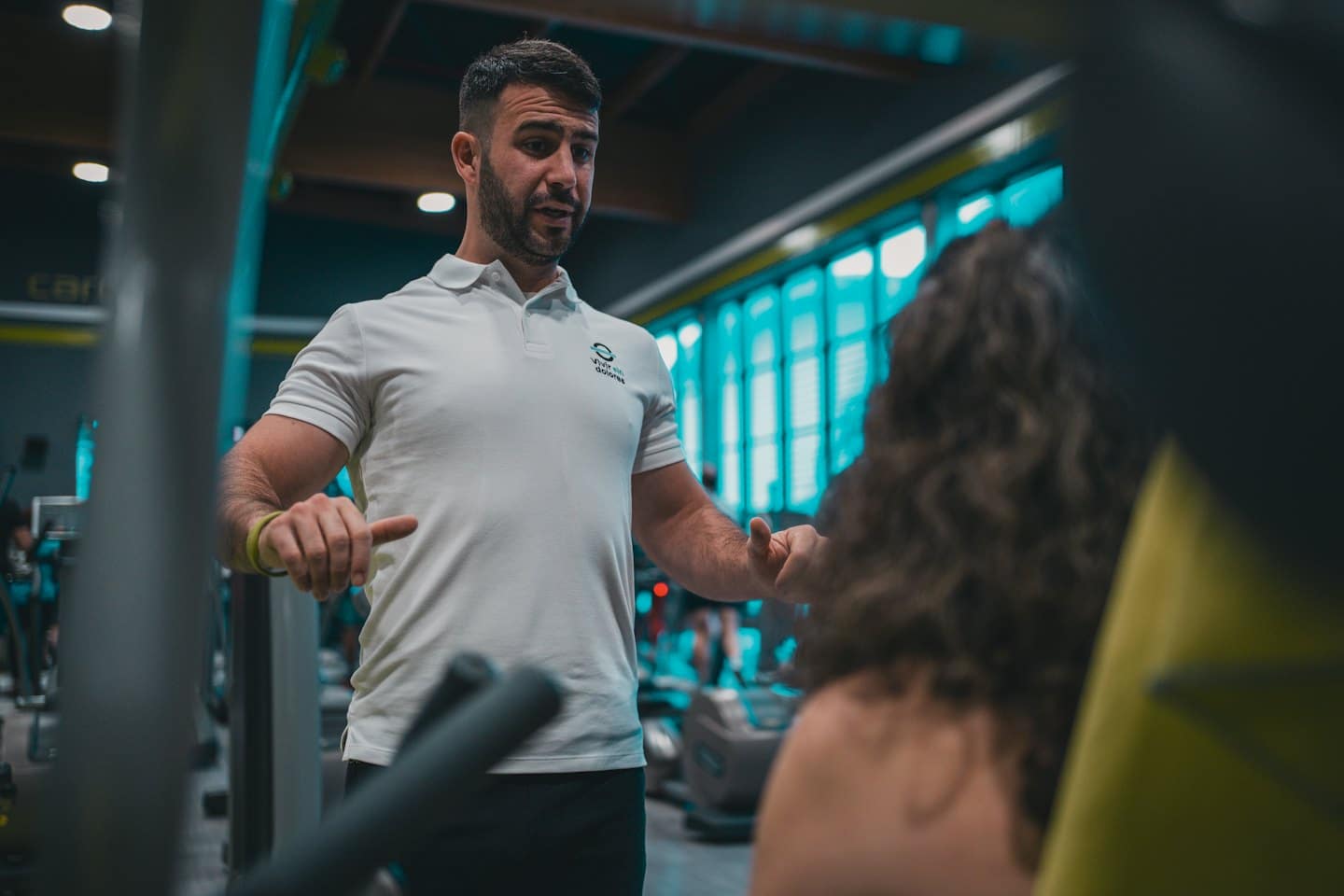 Un personal trainer che mostra un esercizio a un cliente in palestra.